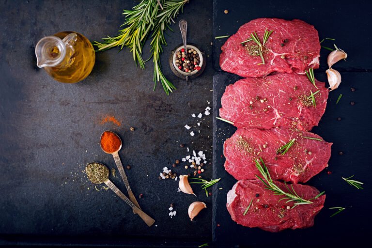 Raw beef steaks with spices and rosemary. Flat lay
